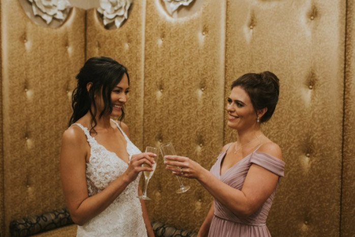 Bride and Maid of honor toasting in The Grandview's Wedding Suite